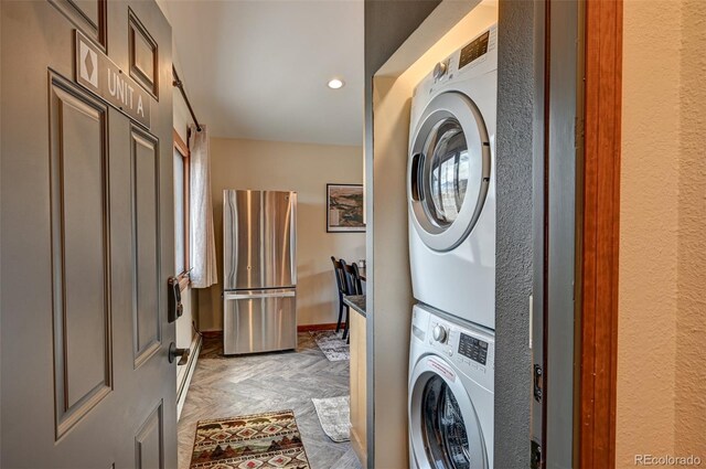 laundry room with laundry area, recessed lighting, stacked washing maching and dryer, and baseboards