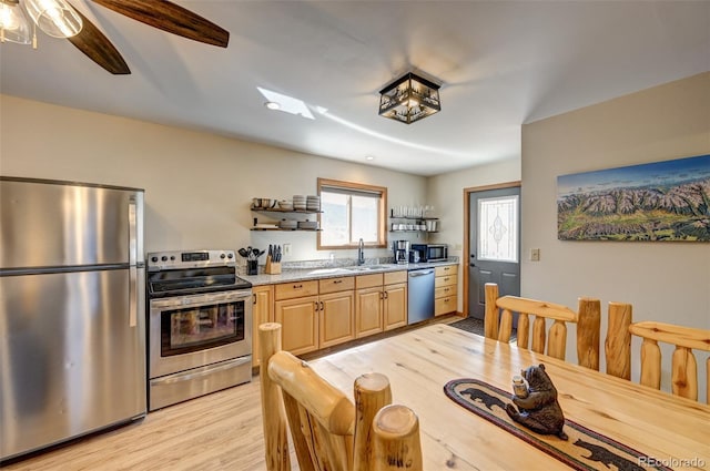 kitchen featuring light stone counters, open shelves, appliances with stainless steel finishes, a sink, and light wood-type flooring