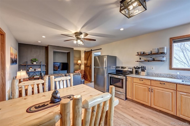 dining area featuring a barn door, recessed lighting, light wood-style flooring, and a ceiling fan