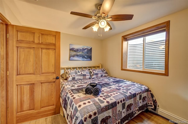 bedroom with ceiling fan, wood finished floors, and baseboards