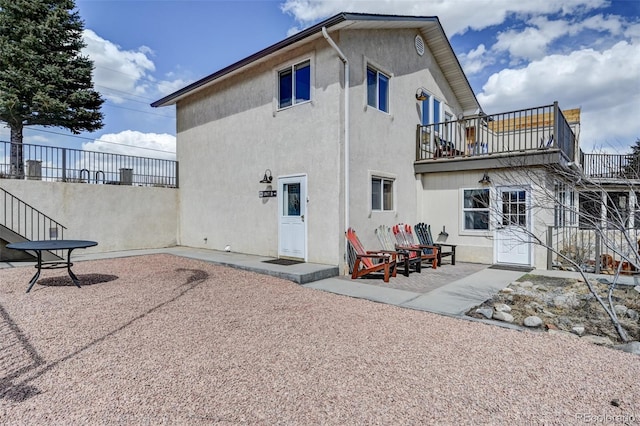 back of property with a patio area, fence, a balcony, and stucco siding