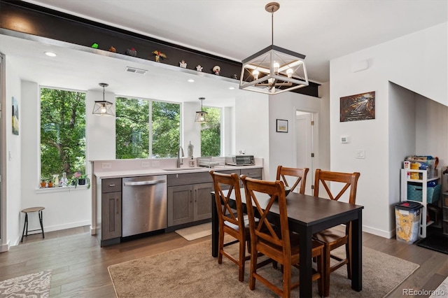 dining space with dark hardwood / wood-style floors, a chandelier, and sink