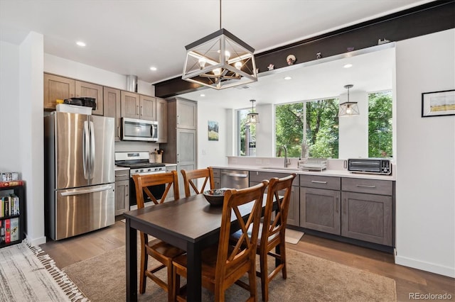 dining space featuring a notable chandelier, sink, and hardwood / wood-style floors