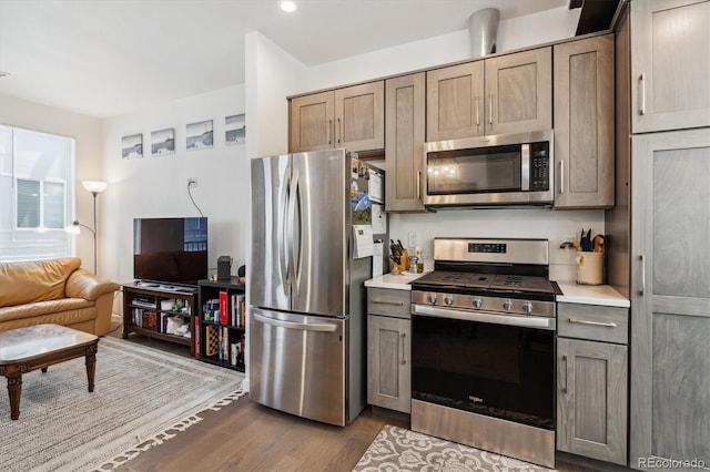 kitchen with appliances with stainless steel finishes and dark hardwood / wood-style floors