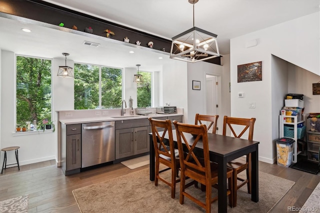 dining room featuring sink, dark wood-type flooring, and an inviting chandelier