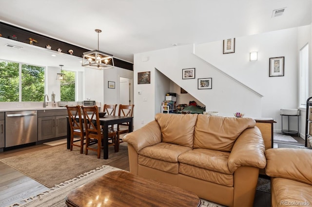 living room with wood-type flooring, sink, and a chandelier