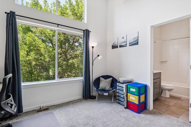 tiled bedroom with connected bathroom and multiple windows