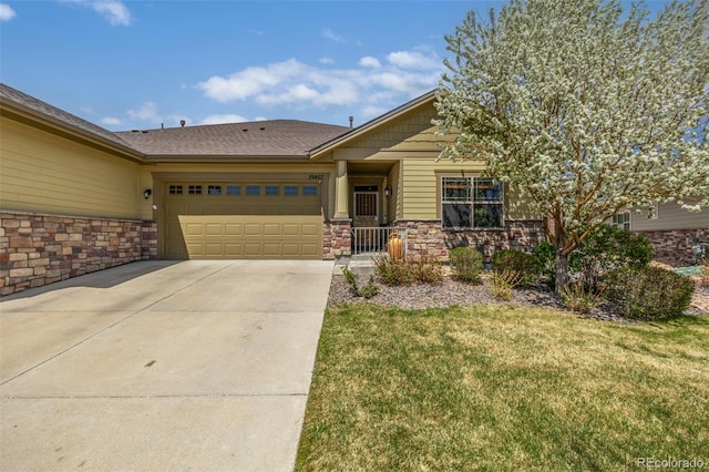 view of front of house featuring an attached garage, driveway, a front yard, and stone siding