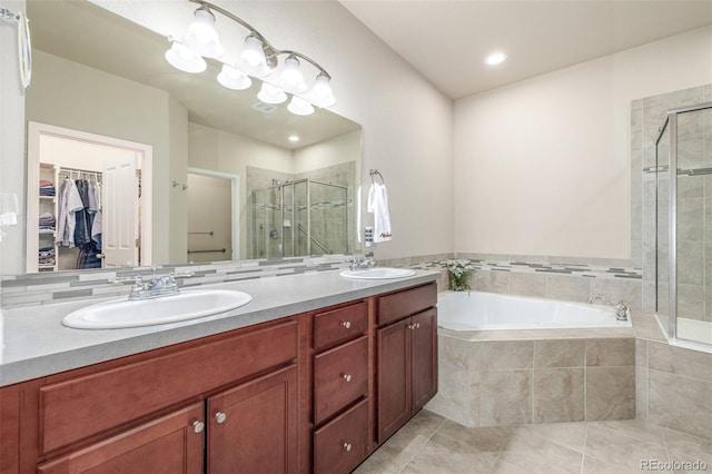 bathroom with a stall shower, a spacious closet, a bath, tile patterned flooring, and double vanity