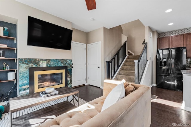 living room with ceiling fan, dark hardwood / wood-style floors, and a high end fireplace