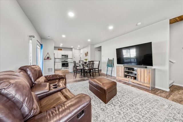 3674 Ronald Reagan Ave, Wellington, CO 80549 - living area with wood finished floors, recessed lighting, baseboards, and stairs