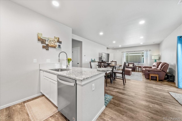 3674 Ronald Reagan Ave, Wellington, CO 80549 - kitchen featuring a sink, stainless steel dishwasher, light stone countertops, light wood finished floors, and recessed lighting