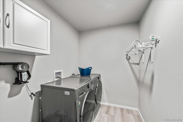 3674 Ronald Reagan Ave, Wellington, CO 80549 - laundry room featuring cabinet space, washer and dryer, light wood-style floors, and baseboards