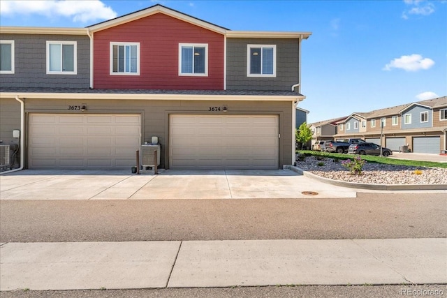3674 Ronald Reagan Ave, Wellington, CO 80549 - view of front of home with an attached garage, cooling unit, driveway, and a residential view