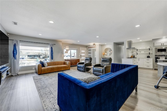 living room with light hardwood / wood-style floors and a textured ceiling