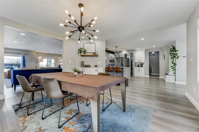 dining area with a chandelier and light hardwood / wood-style flooring