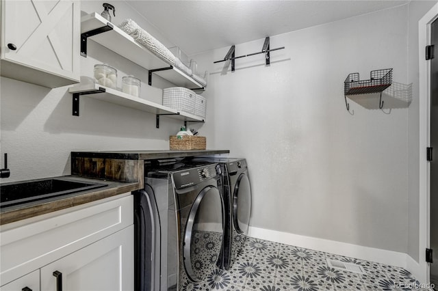 clothes washing area with cabinets and independent washer and dryer