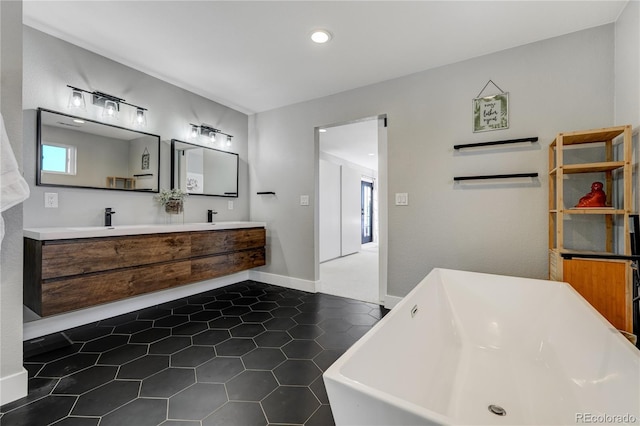 bathroom with tile patterned flooring, vanity, and a washtub