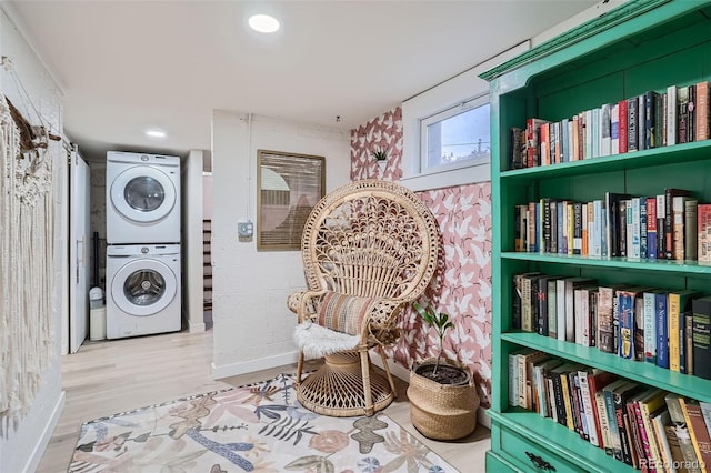 living area with light hardwood / wood-style flooring and stacked washer / drying machine