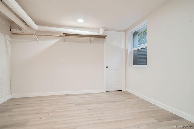 walk in closet with light hardwood / wood-style flooring