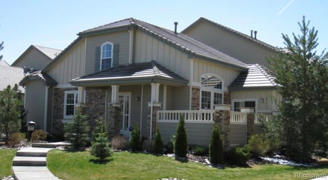 8911 Tappy Toorie Pl, Highlands Ranch, CO 80129 - craftsman-style home with stone siding and a front lawn