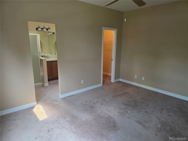 8911 Tappy Toorie Pl, Highlands Ranch, CO 80129 - unfurnished bedroom with a walk in closet, light colored carpet, and ensuite bathroom