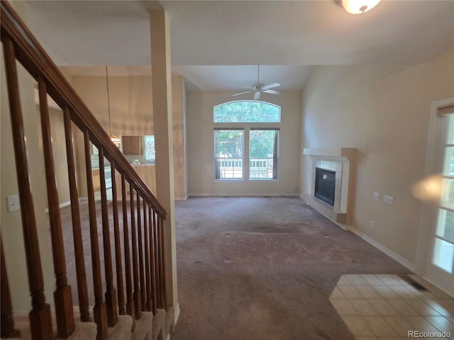 8911 Tappy Toorie Pl, Highlands Ranch, CO 80129 - unfurnished living room with carpet, a tiled fireplace, a ceiling fan, stairway, and lofted ceiling