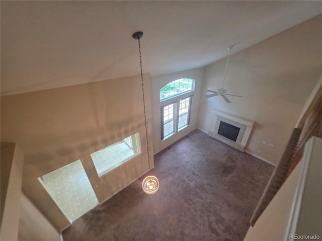 8911 Tappy Toorie Pl, Highlands Ranch, CO 80129 - unfurnished living room featuring a tiled fireplace, carpet floors, a ceiling fan, and high vaulted ceiling
