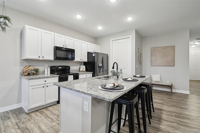 2328 Saddle Back Ct, Fort Lupton, CO 80621 - kitchen with black appliances, a sink, light wood-style floors, and recessed lighting