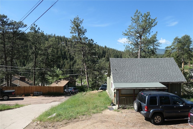 28127 Knowles Rd Unit A, B, & C, Evergreen, CO 80439 - view of property exterior with a shingled roof and a wooded view