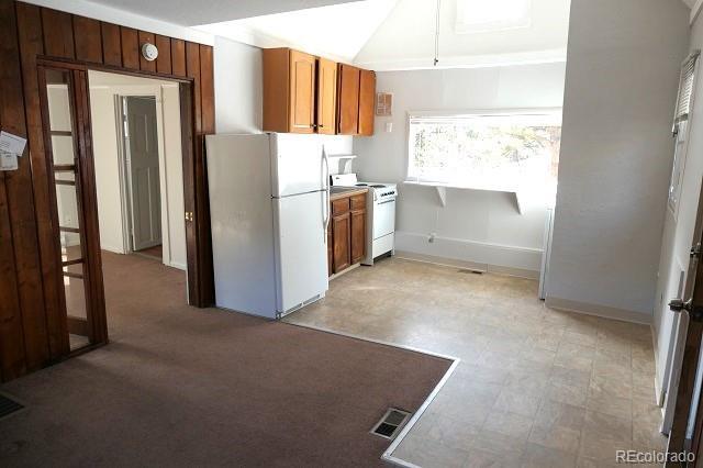 28127 Knowles Rd Unit A, B, & C, Evergreen, CO 80439 - kitchen featuring white appliances, vaulted ceiling, and brown cabinets