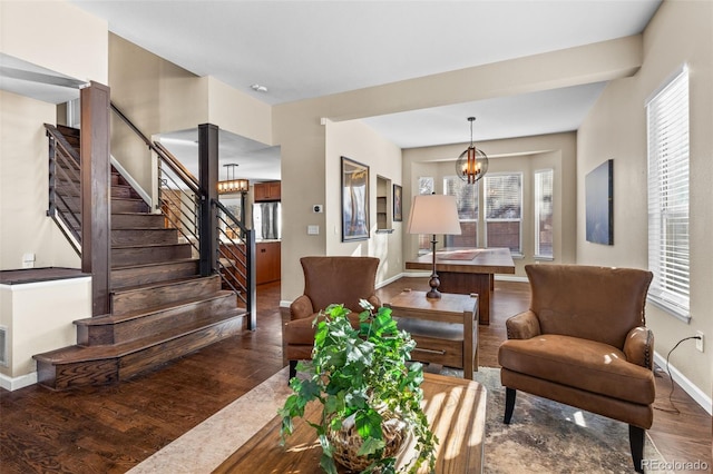 living room with dark wood-type flooring and a notable chandelier