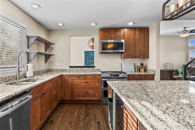 kitchen featuring ceiling fan, sink, light stone counters, dark hardwood / wood-style flooring, and appliances with stainless steel finishes