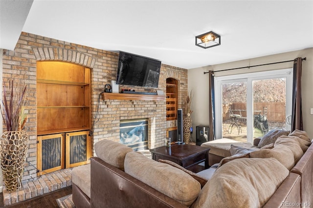 living room with dark hardwood / wood-style floors and a brick fireplace