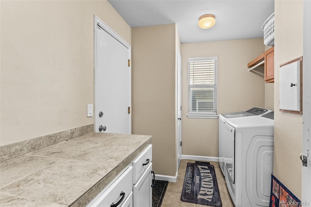 washroom featuring cabinets, light tile patterned floors, and washing machine and clothes dryer