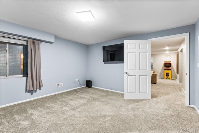 carpeted empty room featuring a textured ceiling