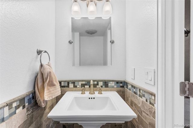 bathroom with sink and tile walls