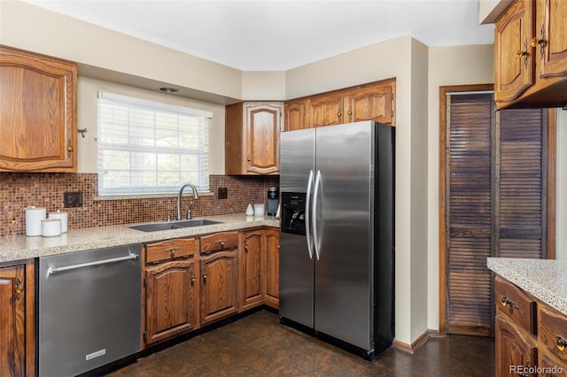 9867 W Berry Dr, Littleton, CO 80123 - kitchen with stainless steel appliances, a sink, decorative backsplash, brown cabinets, and baseboards