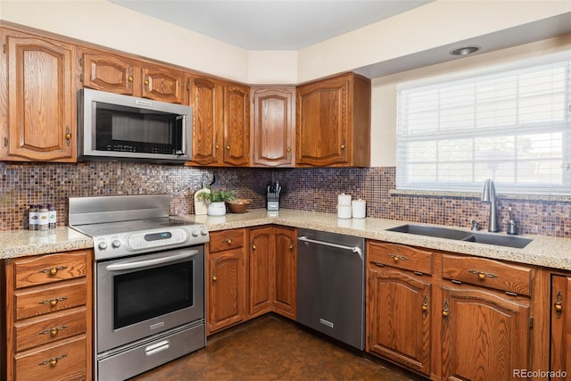 9867 W Berry Dr, Littleton, CO 80123 - kitchen with stainless steel appliances, a sink, brown cabinetry, and decorative backsplash