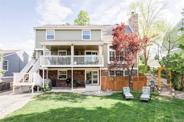 9867 W Berry Dr, Littleton, CO 80123 - rear view of house with a patio, a chimney, brick siding, a wooden deck, and stairs