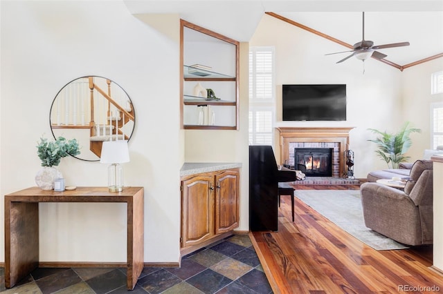 9867 W Berry Dr, Littleton, CO 80123 - living area featuring a fireplace, a ceiling fan, lofted ceiling, baseboards, and ornamental molding