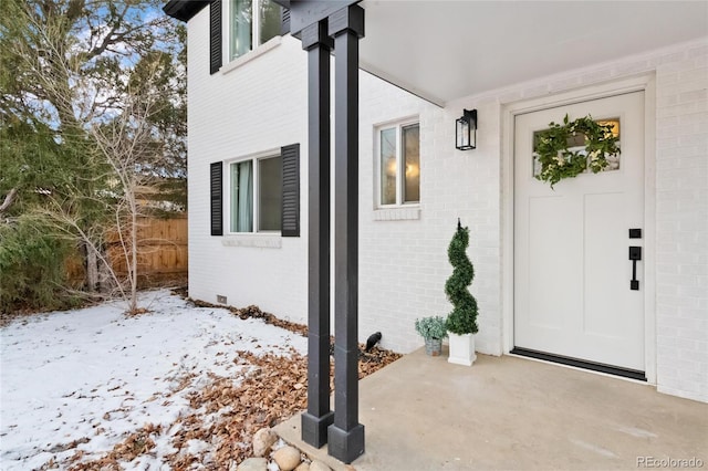 view of exterior entry with brick siding