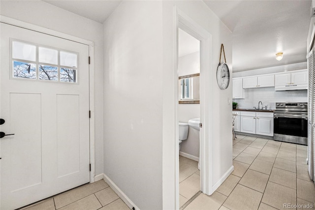 entrance foyer with a healthy amount of sunlight, baseboards, and light tile patterned floors