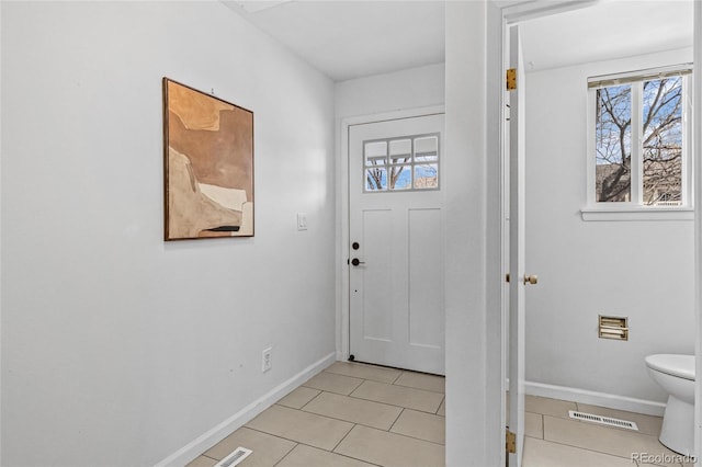 doorway to outside with visible vents, baseboards, and light tile patterned floors