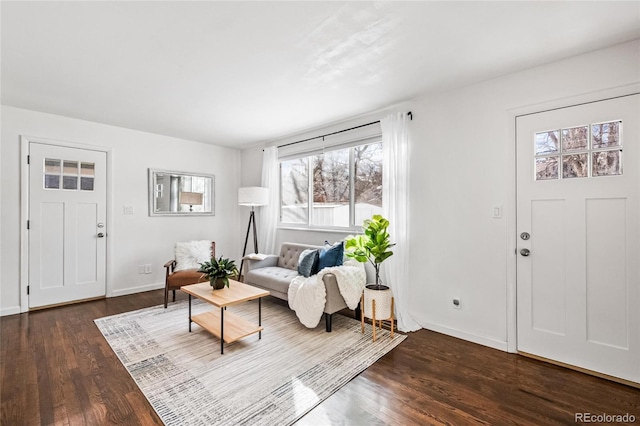 living room featuring dark wood-type flooring and baseboards