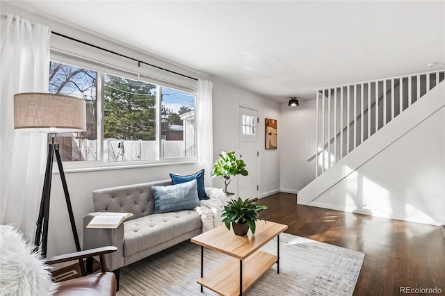 living room with stairway, wood finished floors, and baseboards