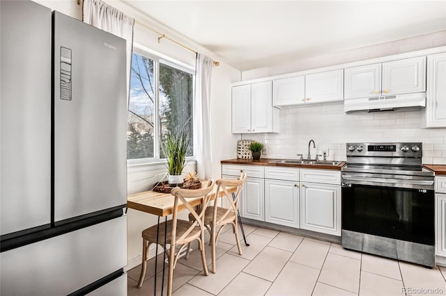 kitchen featuring stainless steel appliances, butcher block counters, a sink, and under cabinet range hood