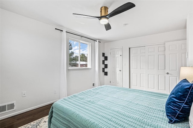 bedroom with a closet, visible vents, a ceiling fan, wood finished floors, and baseboards