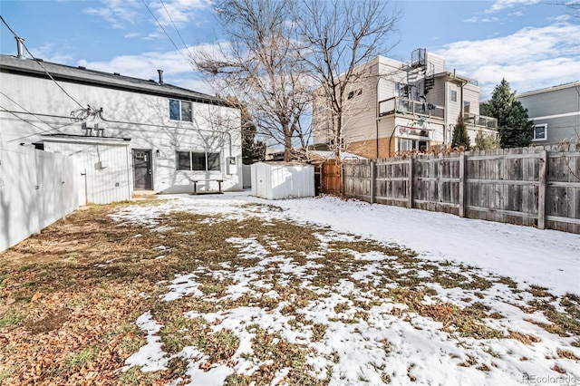 snowy yard with a fenced backyard