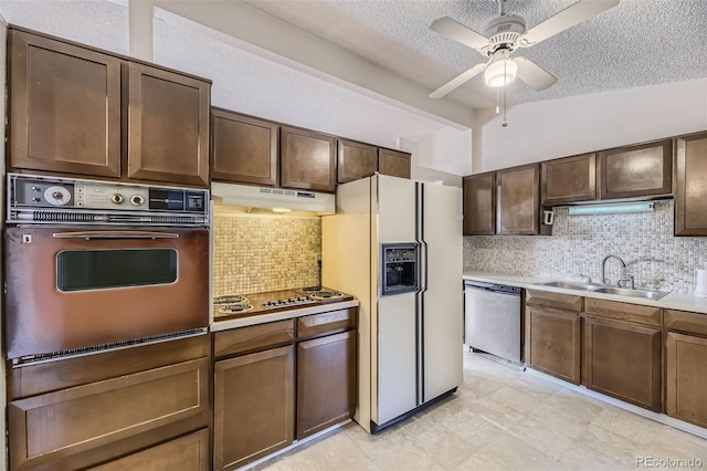 kitchen featuring wall oven, electric stovetop, under cabinet range hood, a sink, and dishwasher